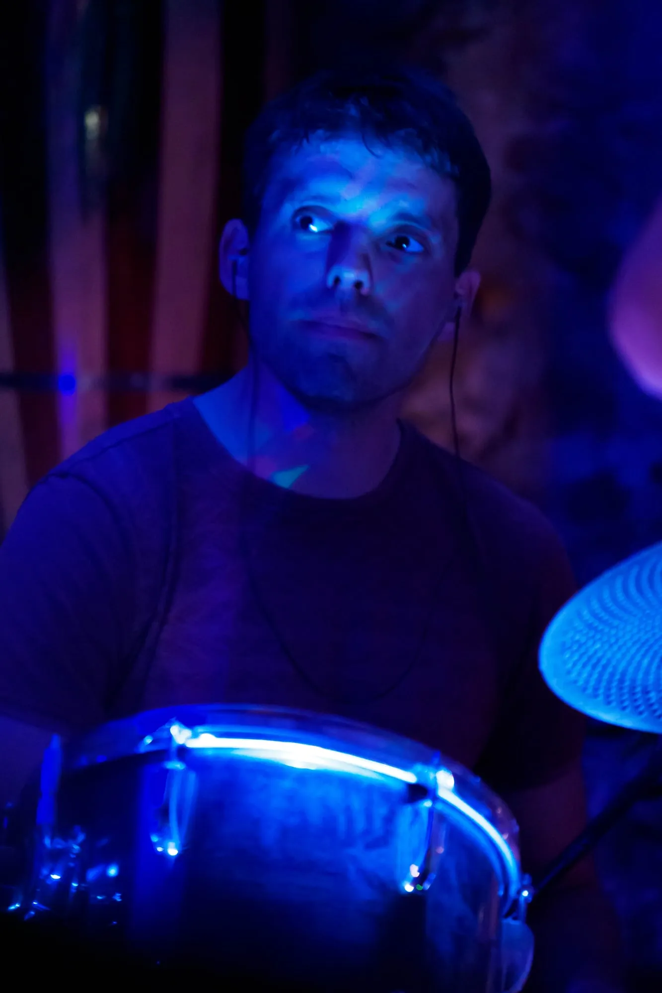 Le batteur derrière ses fûts, lumière bleue